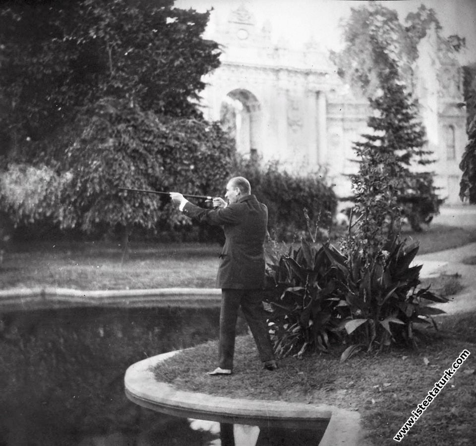 Mustafa Kemal Atatürk Dolmabahçe Sarayı'nda kendisine armağan edilen baston-tüfeği kullanırken. (03.09.1928)