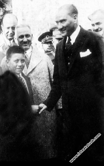 Yalova'da tanıyıp himayesine aldığı sığırtmaç Mustafa ile öğretmeni İle birlikte Dolmabahçe Sarayının önünde. (19 Eylül 1930)